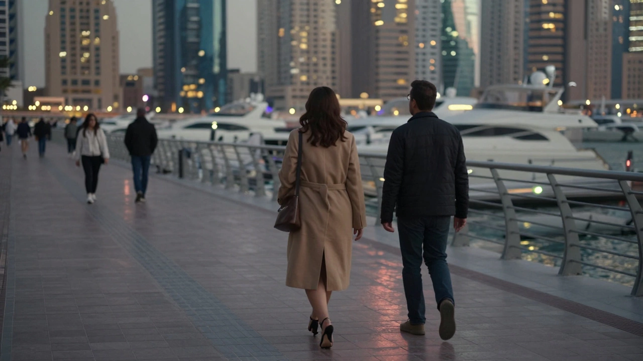 A woman and man walking peacefully along Dubai Marina’s lit promenade at night.